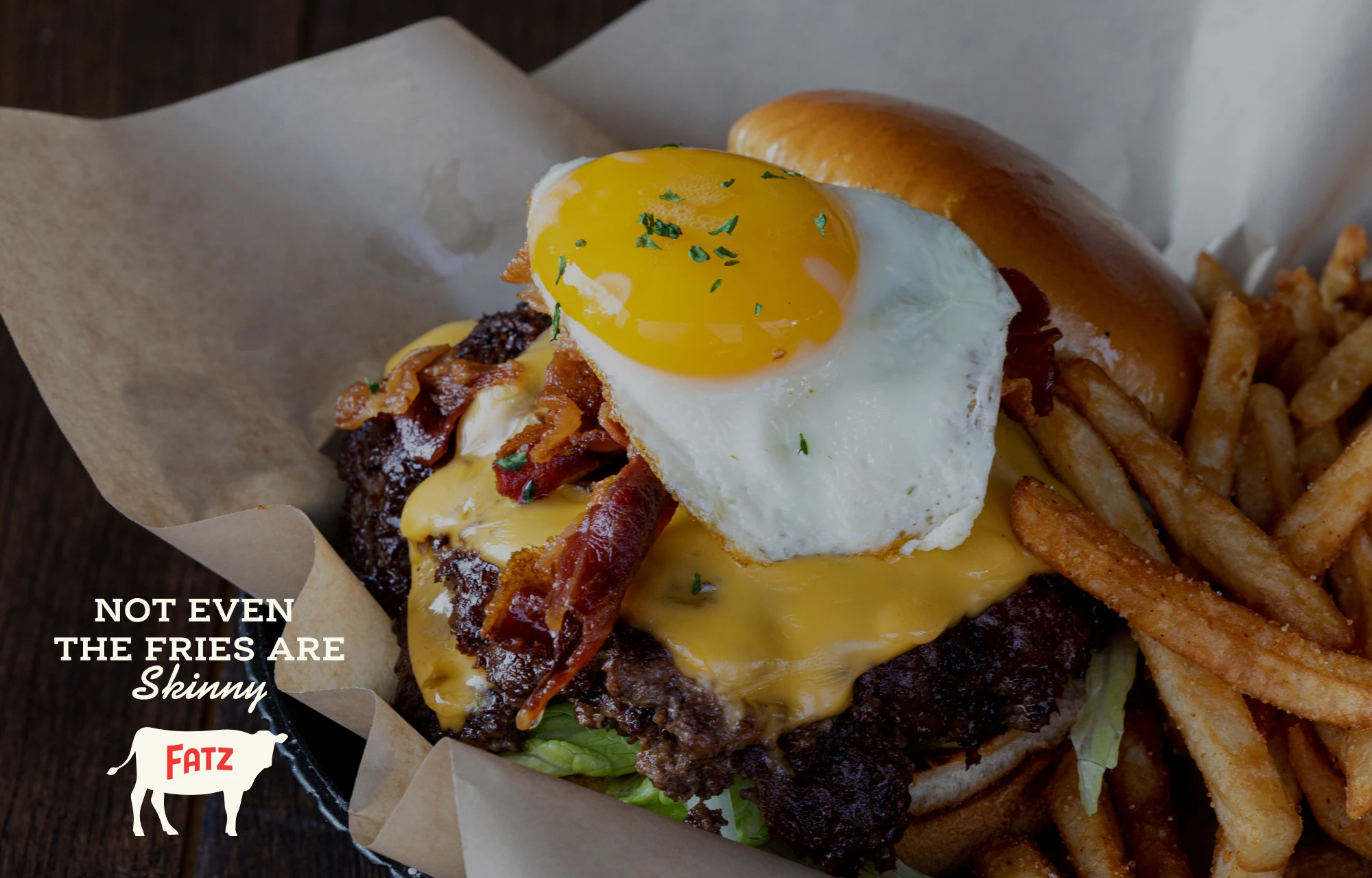 Photo of a juicy double burger and fries with the tagline Not Even the Fries and Skinny