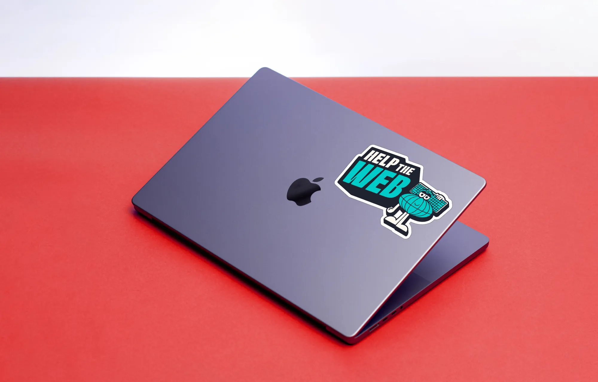 A MacBook Pro slightly cracked open on a red background with a Help The Web sticker on the case