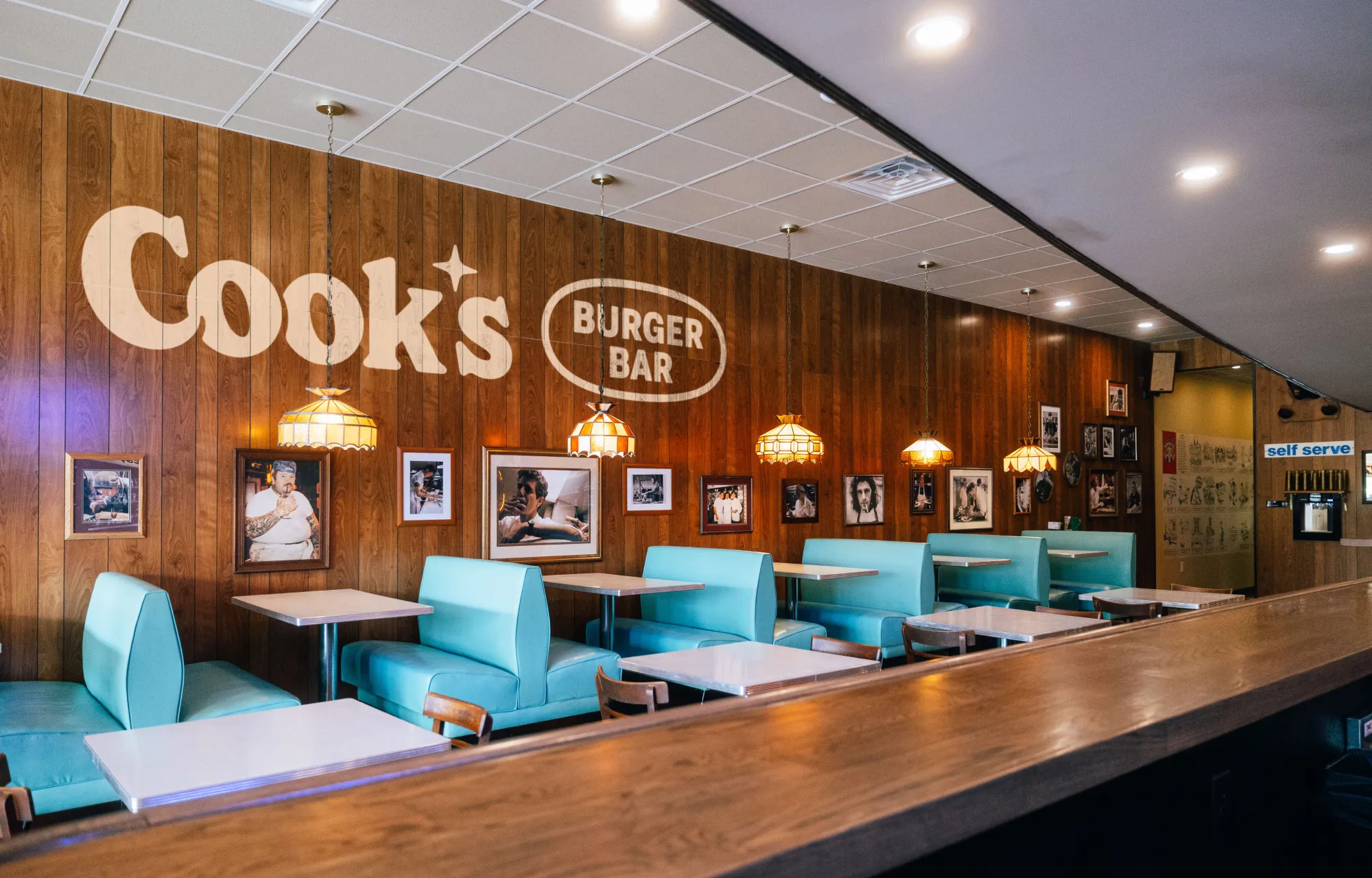 Interior photo of Cook's Burger Bar with a logo mocked up on the wood paneling