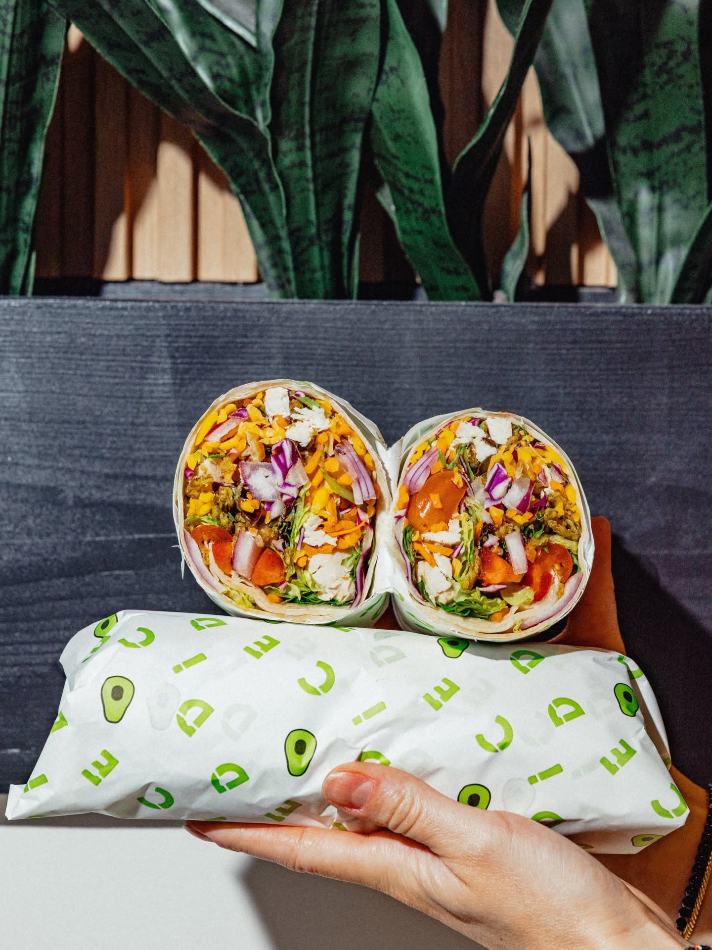 A hand holding two wraps from DICED