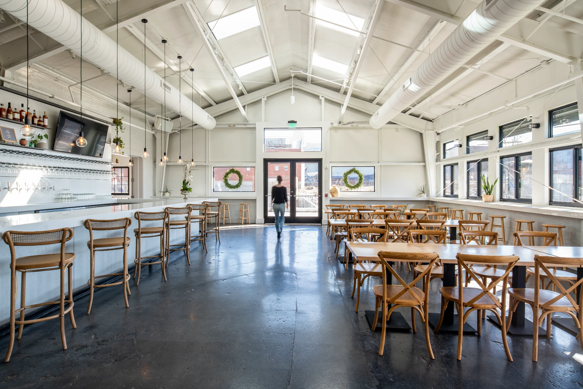 Industrial modern interior of event venue with wood chairs and bright skylights