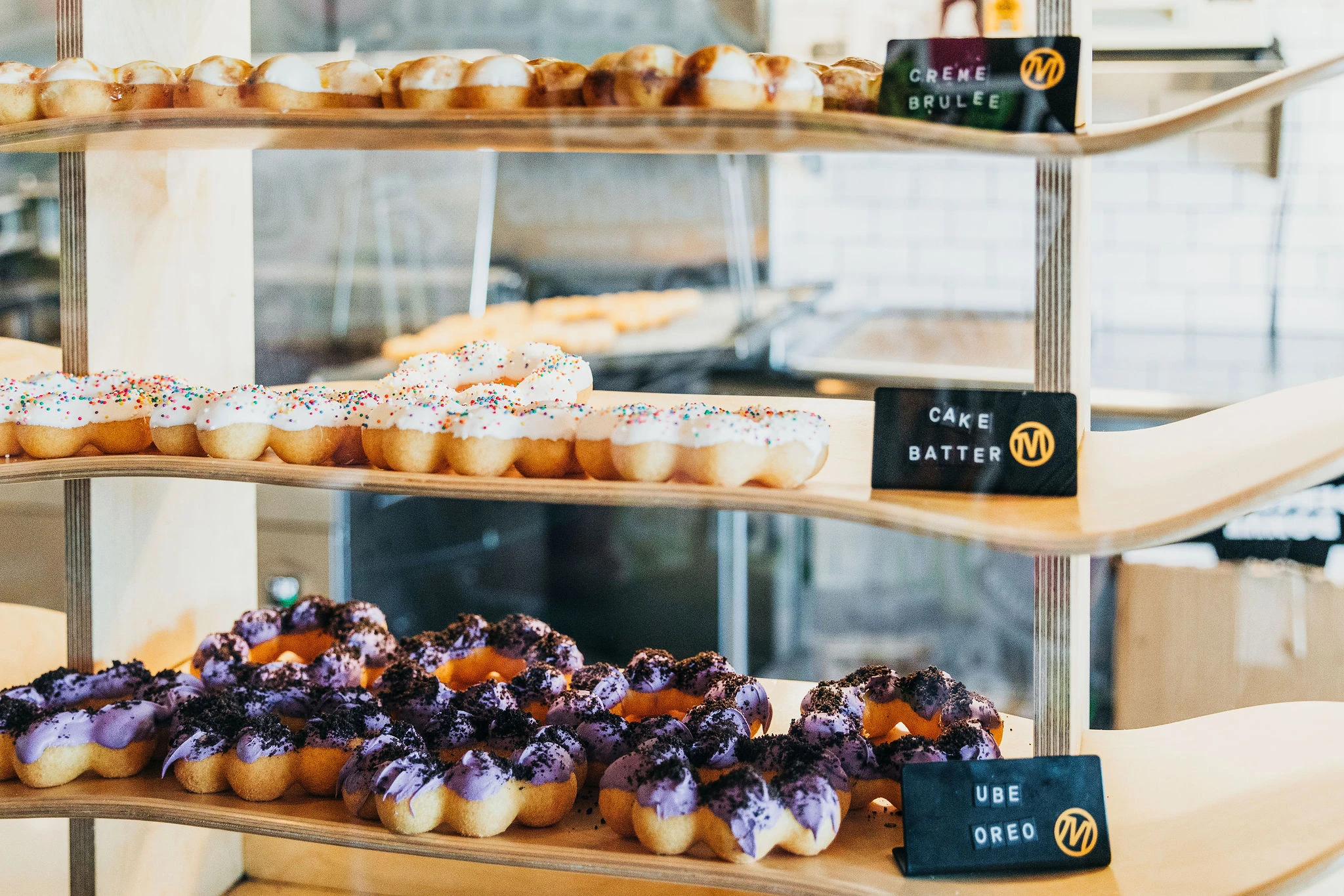 A close up of mochi donuts on shelves made out of skateboards