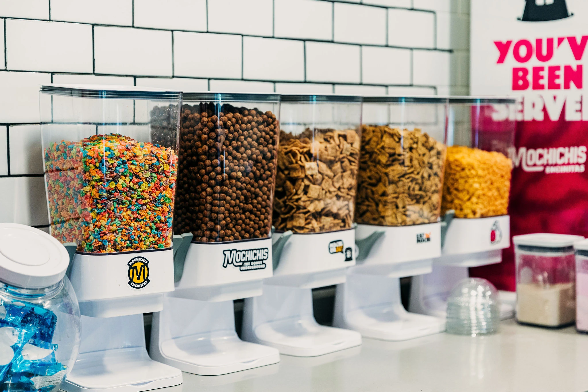 Topping dispensers for soft serve ice cream, customized with Mochichi-branded stickers