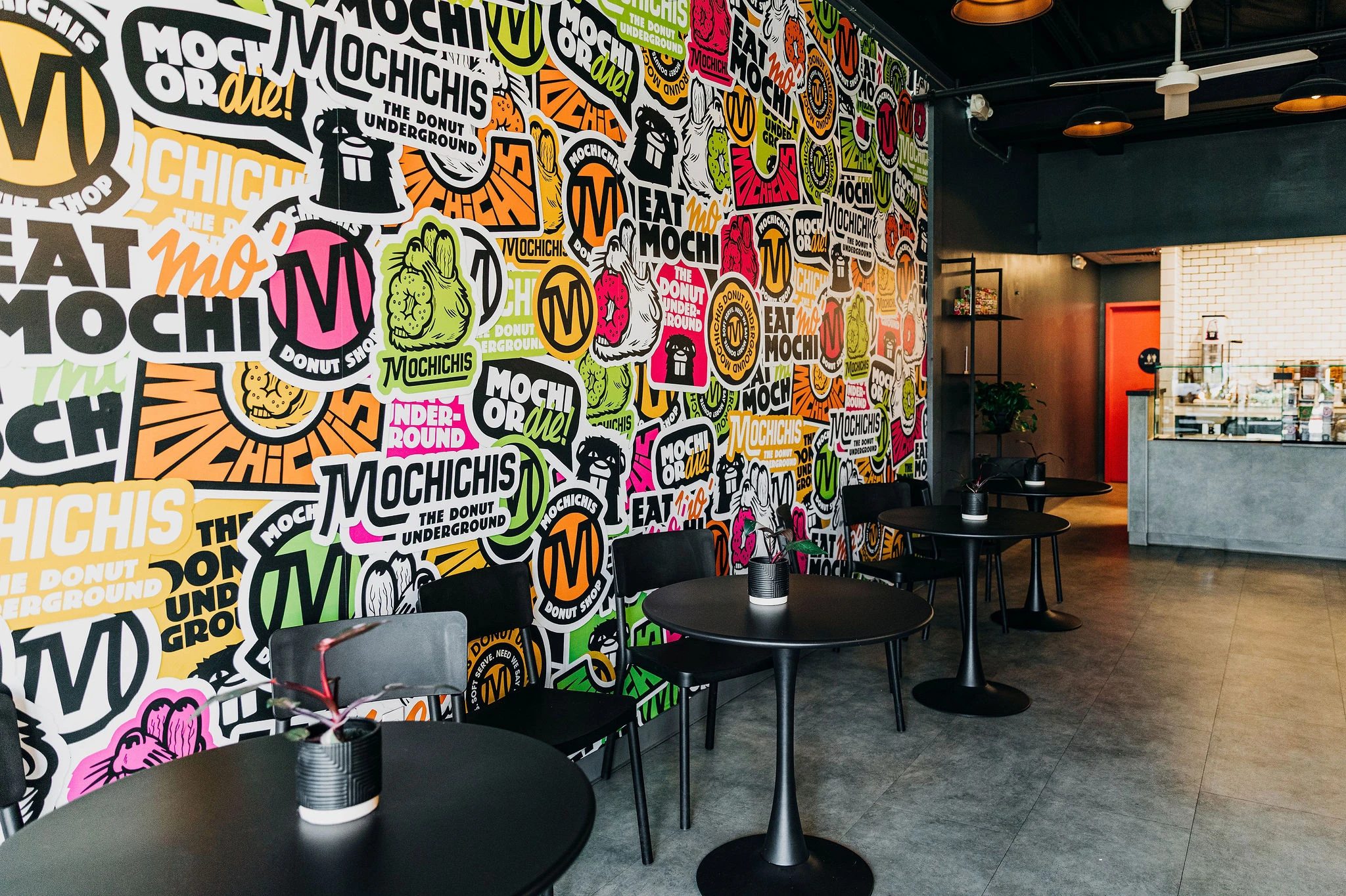 Inside of Mochichi's donut shop, with a large colorful sticker mural