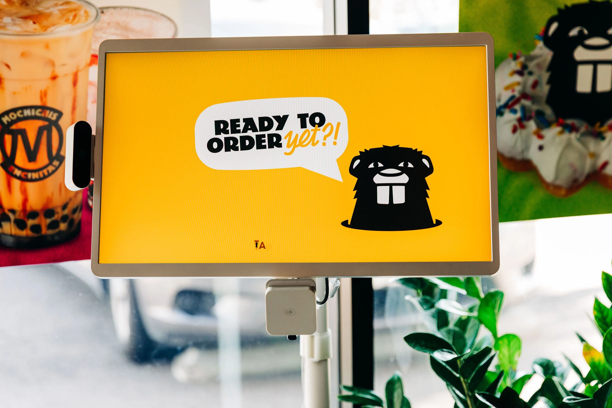 A touchscreen display kiosk with animated loading screen for ordering Mochichi's donuts