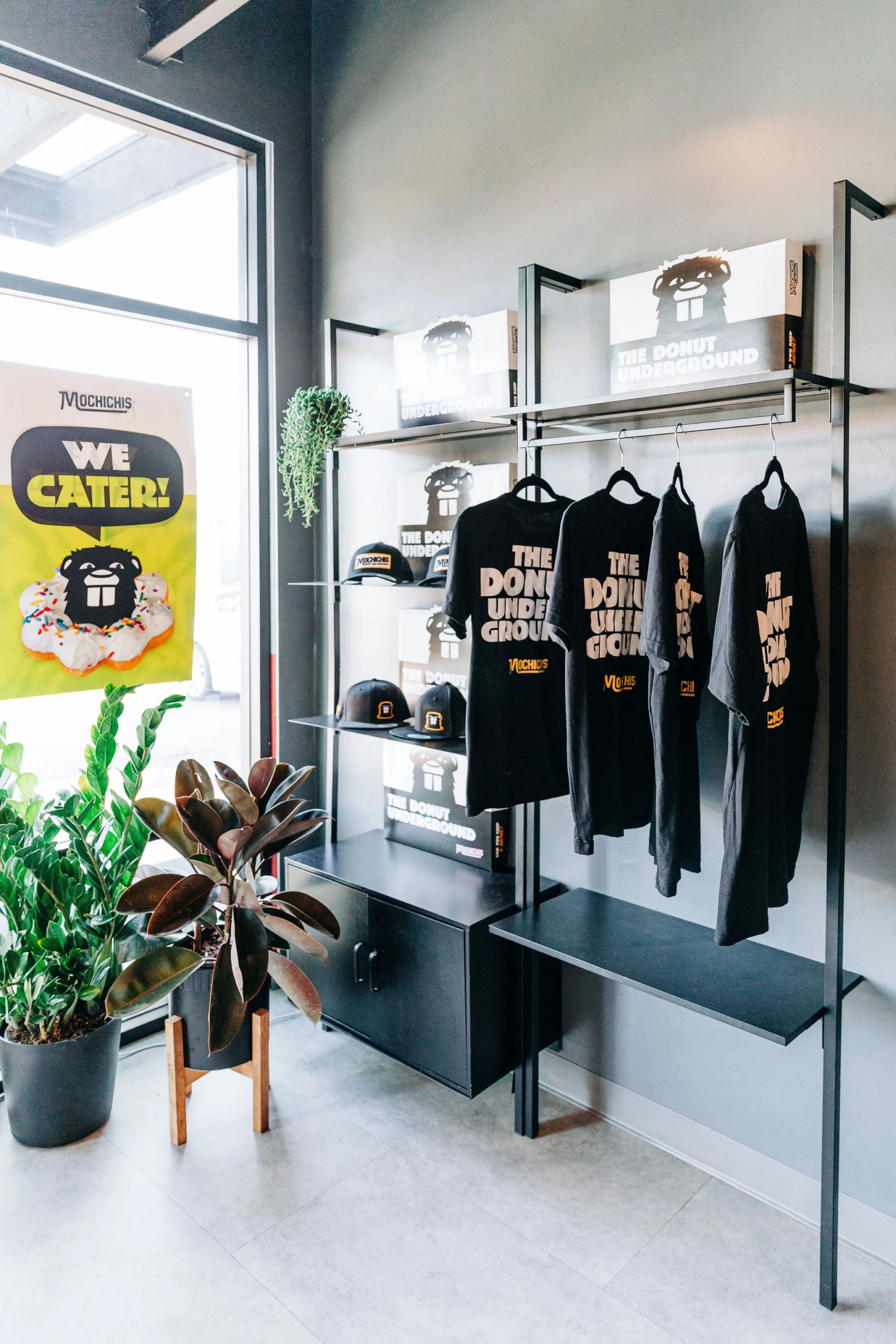 A modern shelving display of merch at Mochichis Donut Shop