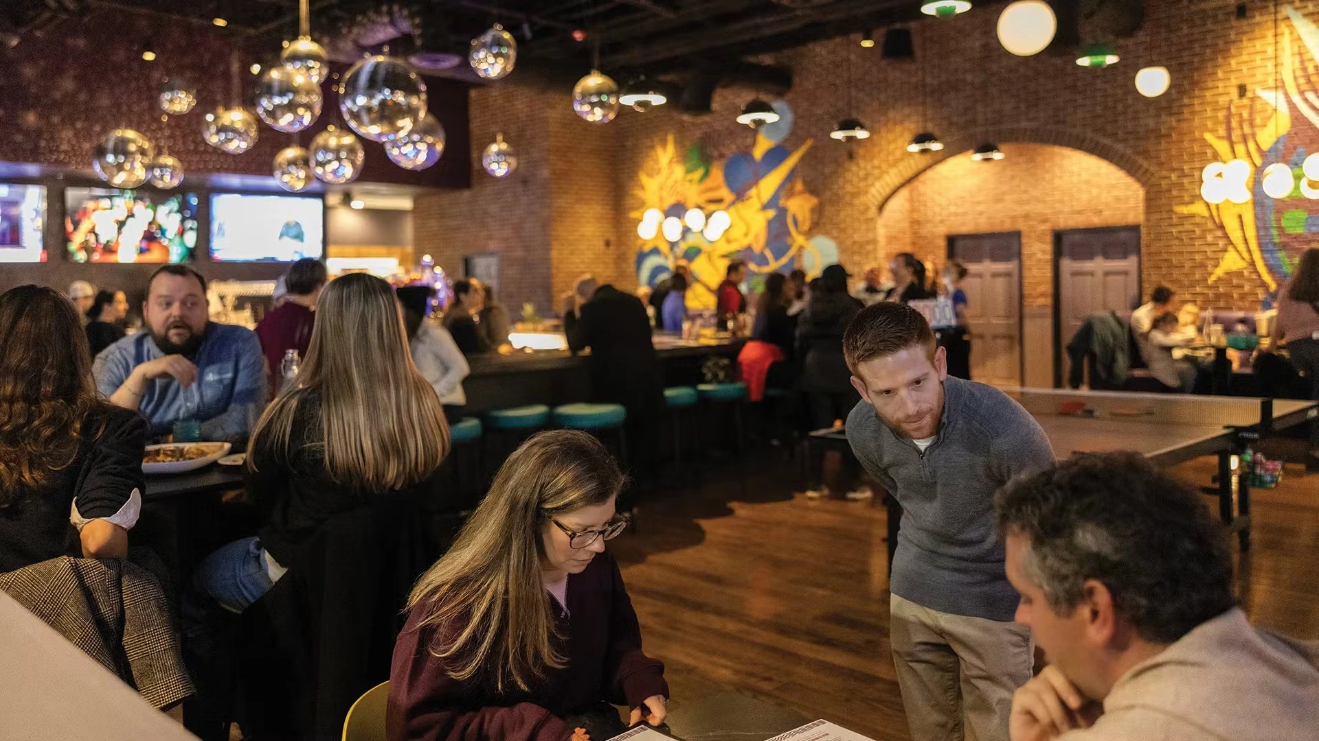 A waiter checks on a table at SMASH Social Club