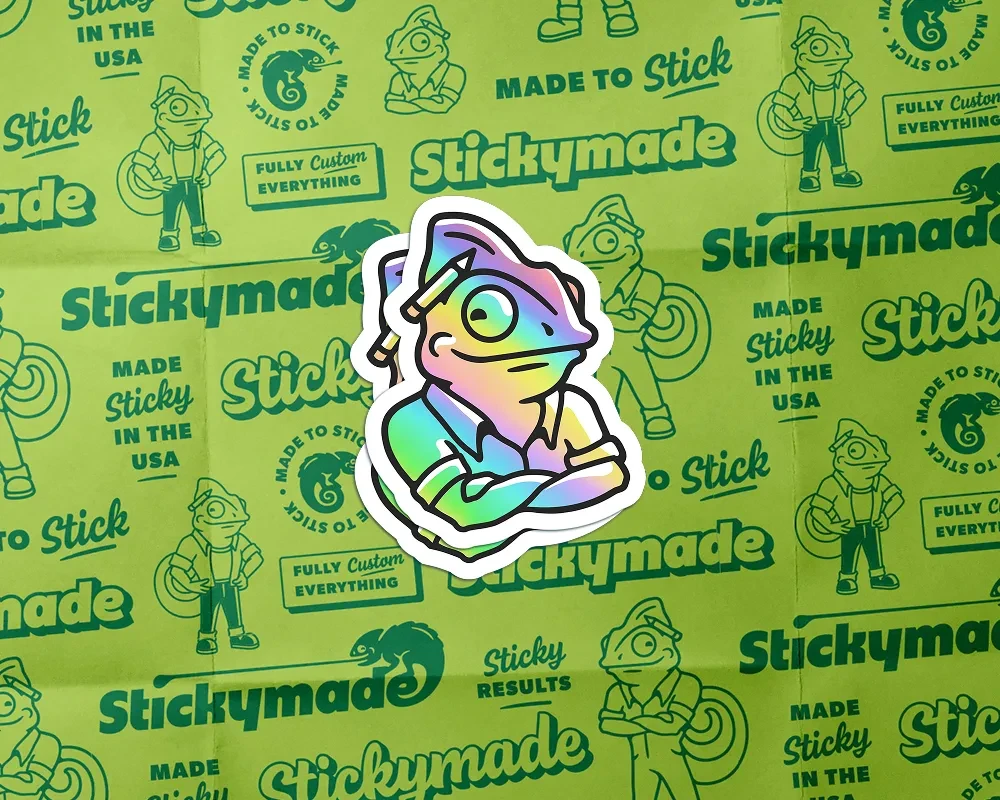 Two holographic stickers of the Stickymade chameleon mascot over a green branded pattern background
