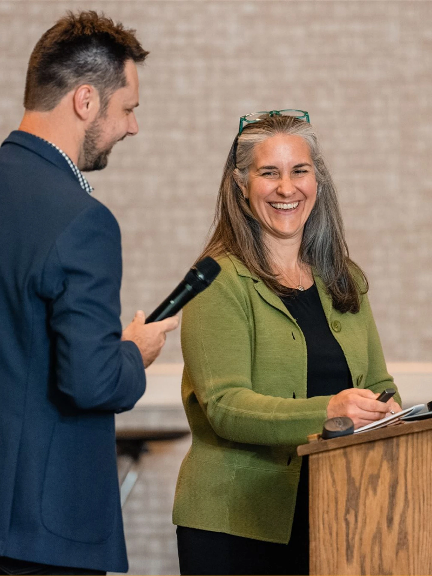 Two employees of The East Group stand at a podium presenting