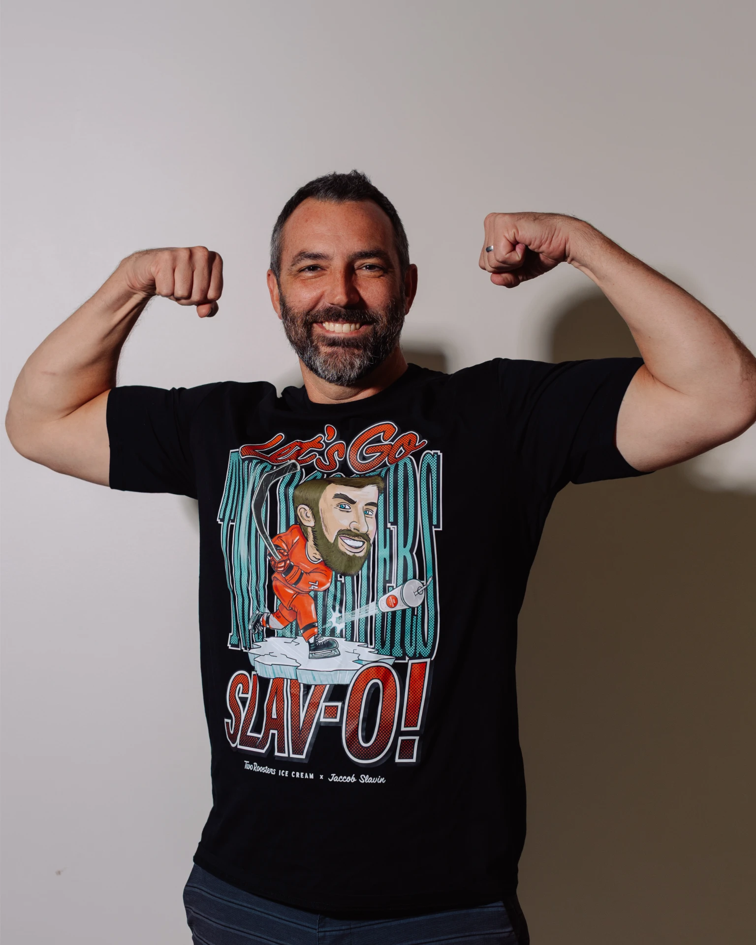 Two Rooster's owner, Jared, flexing in a Jaccob Slavin illustrated shirt