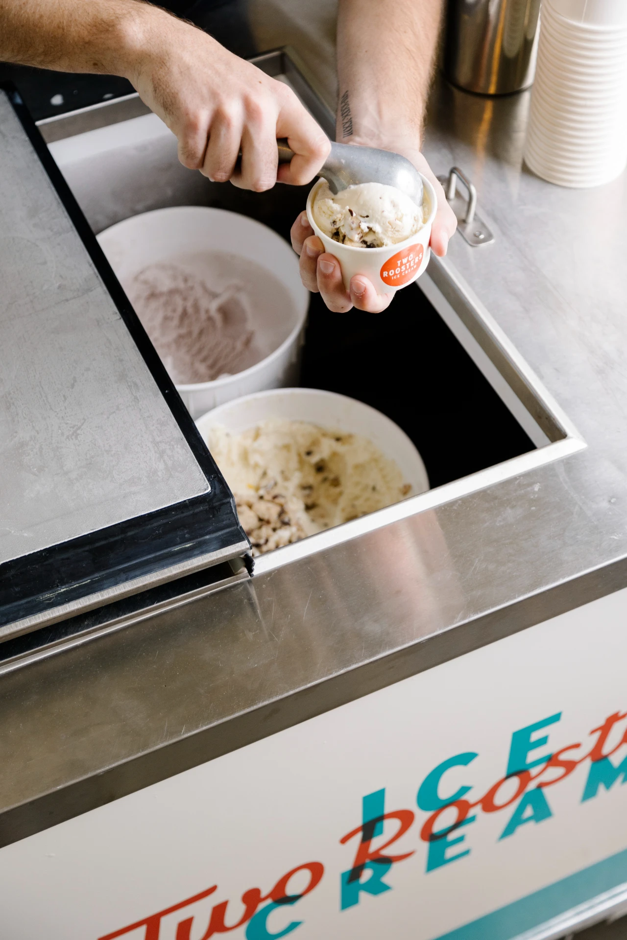 Two Roosters employee scooping at a catered event