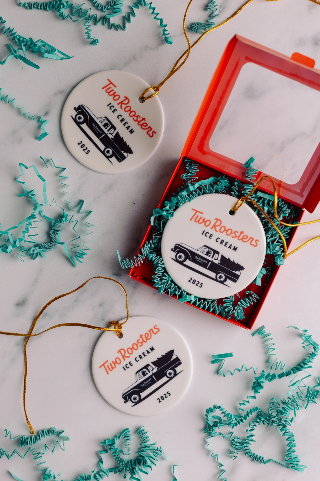 Two Rooster's 2025 ceramic holiday ornament with their logo and an illustration of a vintage truck