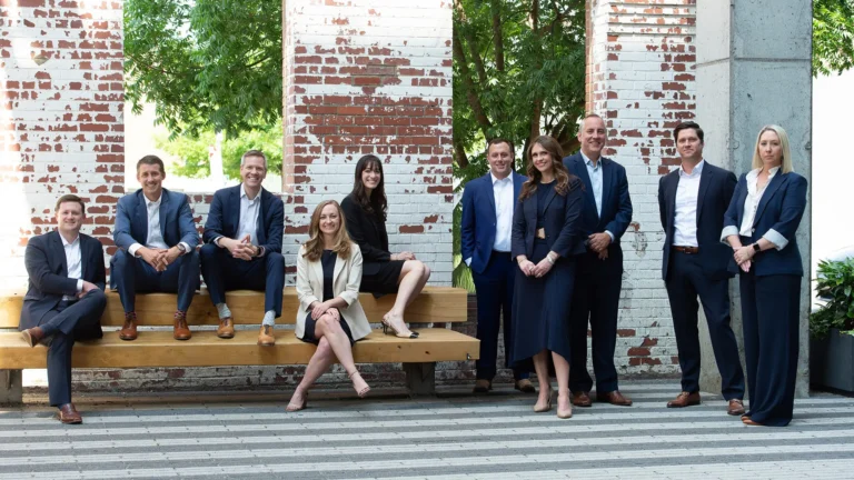 The Lee Segui team of lawyers posing in front of a brick wall