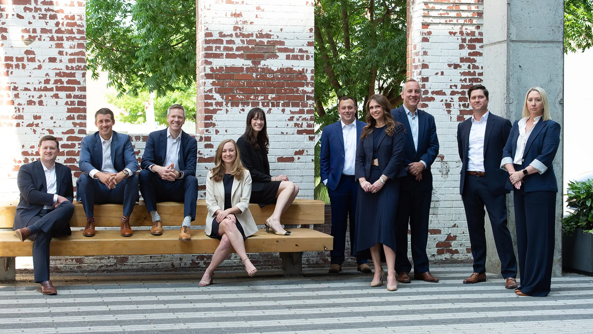The Lee Segui team of lawyers posing in front of a brick wall
