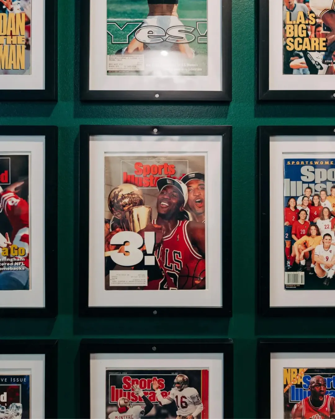 A grid of framed Sports Illustrated magazines from the 90s