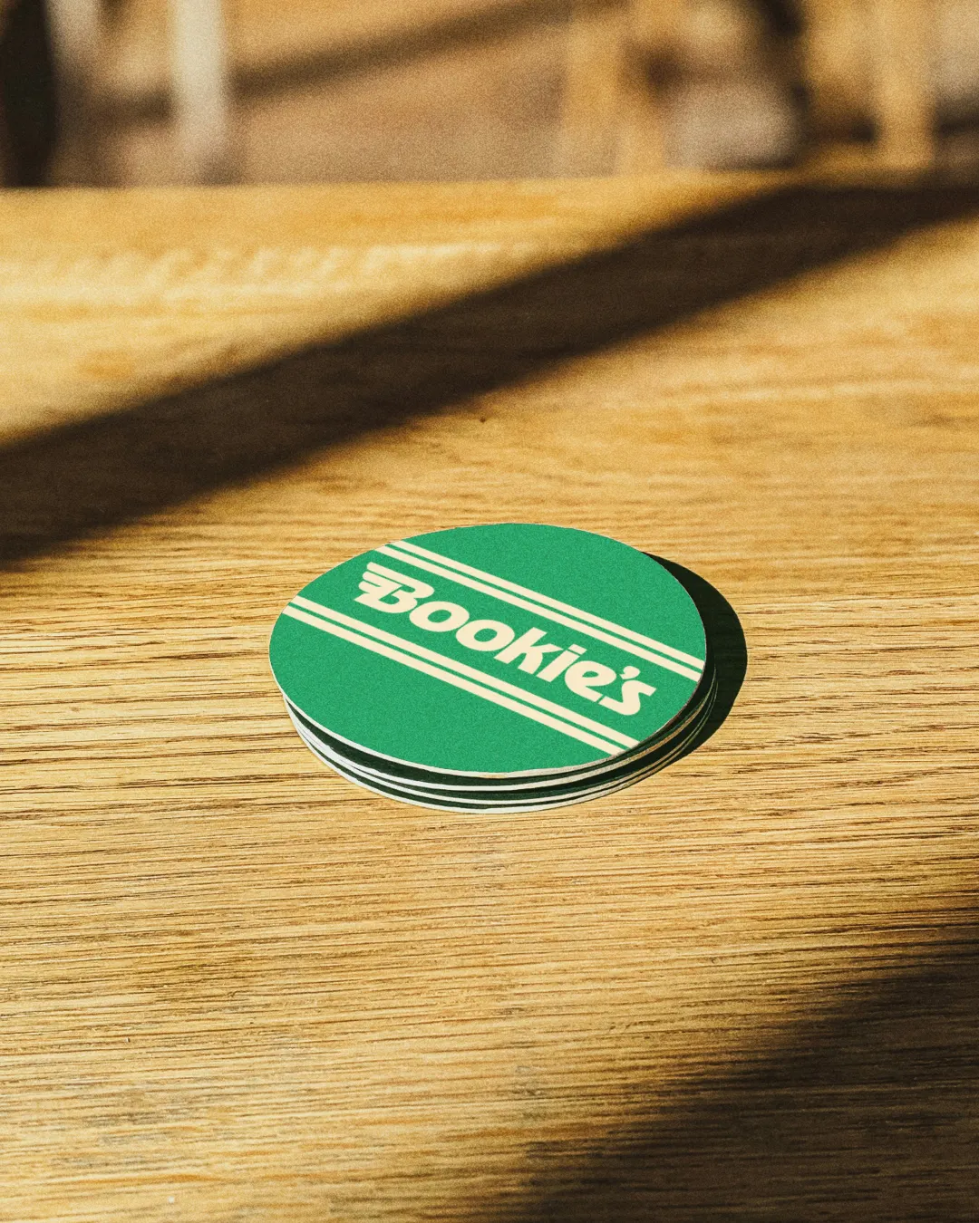 Green drink coasters on a light wood table