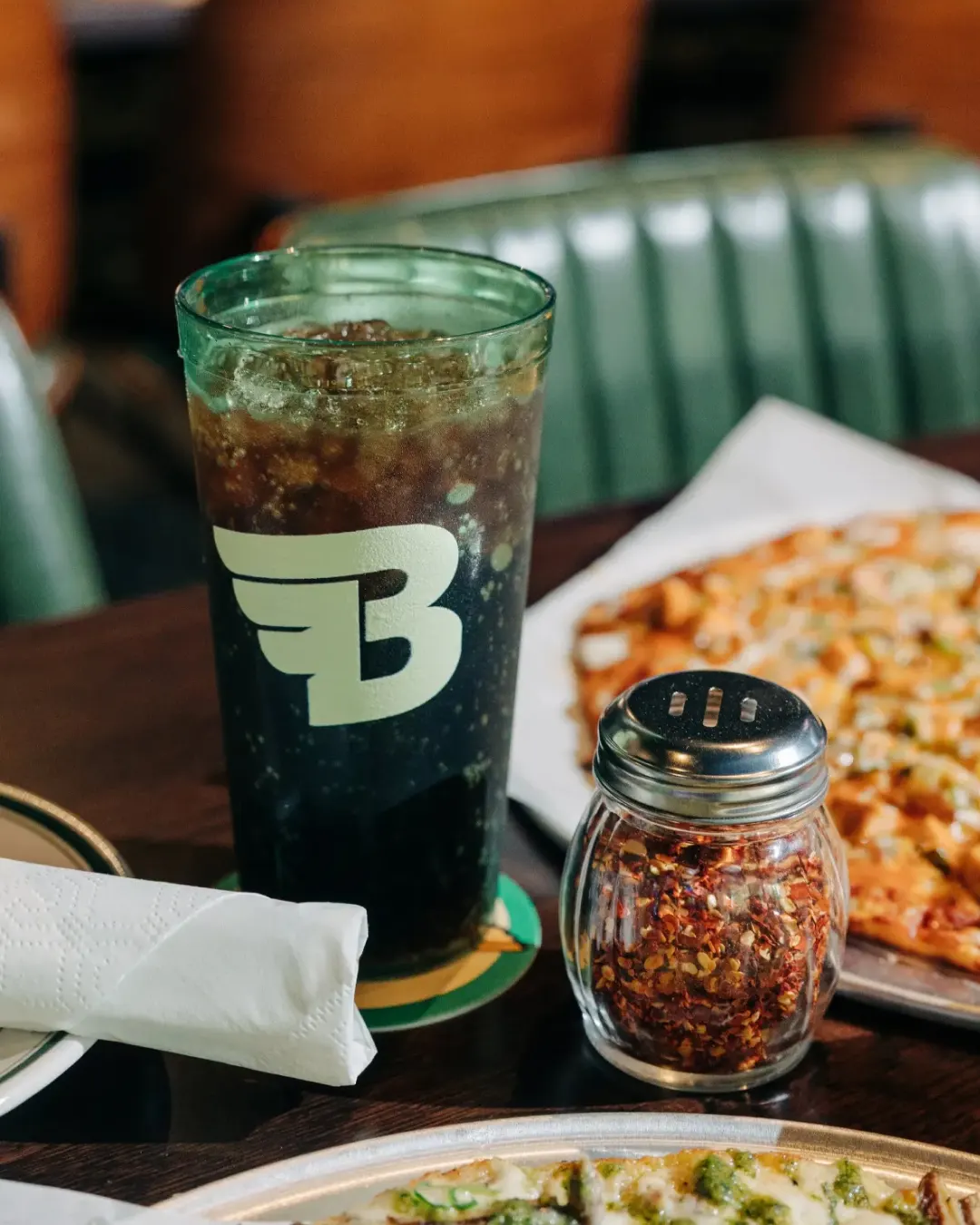 A clear plastic cup with the Bookie's winged B logomark