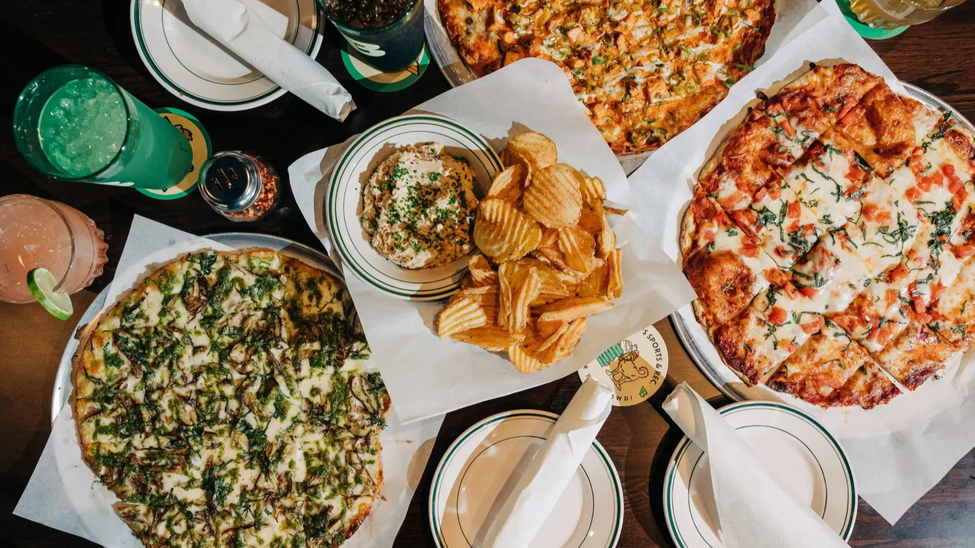 Table spread of pizza, dips and drinks