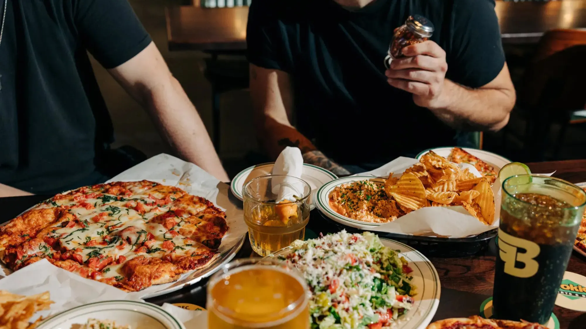 Table spread of pizza, dips and drinks