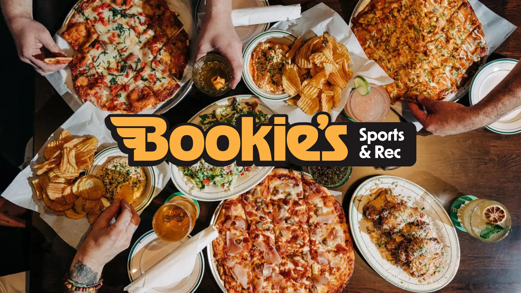 Bookie's Sports and Rec logo over top of a photo of pizzas on a table