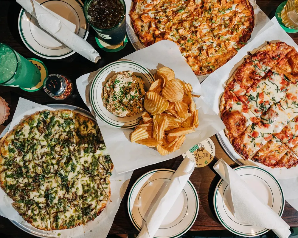 Table spread of pizza, dips and drinks